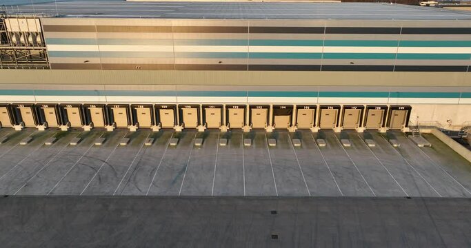 Loading docks for trucks at distribution warehouse. Logistics and transportation of goods. Commercial shipment over road.
