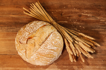 Bread baking photo. Close up view of some ears of wheat next to a fresh bread out of the oven with...