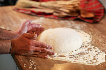 Shaping the sourdough. view from above with male hands while shaping a home made bread dough after the first rise. Home made fresh bread making process.