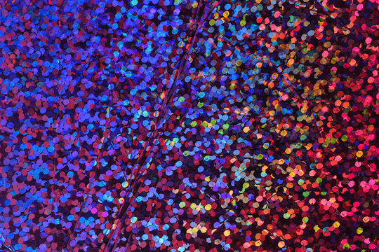 photo of abstract pastel iridescent holographic foil background. holo color wrinkled material. cool glitter surface with shiny rainbow neon feel.