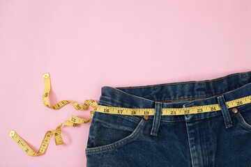 Jeans waist measurement tape On a pink background