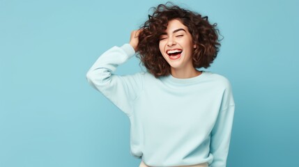 Laughing young joyful woman isolated on blue pastel background with copy space