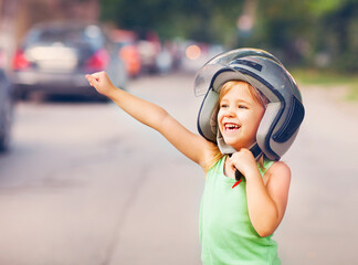 Happy kid playing in helmet outdoors