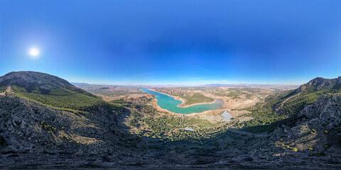 VR image 360 ​​view. Sunrise over reservoir and cliff next to the forest with colorful sunny sky. Colorful water color. Panoramic aerial view. Spain.