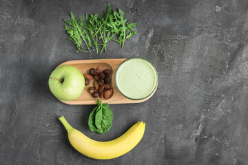 Green detox smoothie in a glass, blended vegetarian drink from spinach leaves, apple, banana fruit...