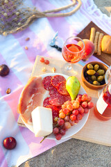 Picnic outdoor with rose wine fruits meat and cheese