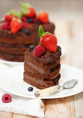 Piece of chocolate cake with icing and fresh berry