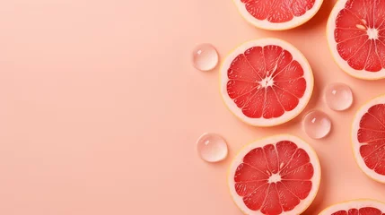 Fotobehang Refreshing Grapefruit Bliss: Top View Photo of Juicy Citrus Slices, Ice Cubes, and Water Drops on Pastel Pink Background with Copy-Space for Summer Promotions © Pasinee