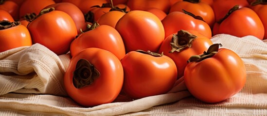 Ripe persimmon pile on tablecloth.