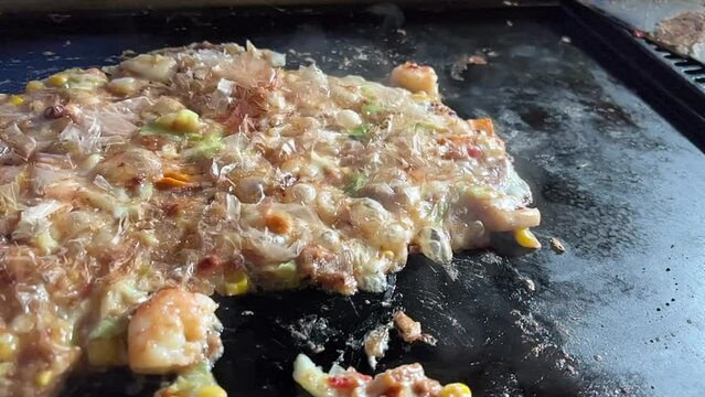 鉄板の上でもんじゃ焼きを焼く