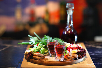 Cranberry Vodka with vegetables. Homemade vodka and appetizers. Vodka with horseradish and vegetable appetizers.