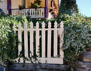 decorative picket fence and porch railing to a vintage Victorian cottage