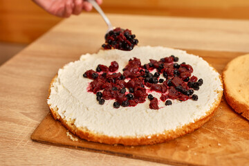Adding the filling to the cake. Cooking a festive pie at home