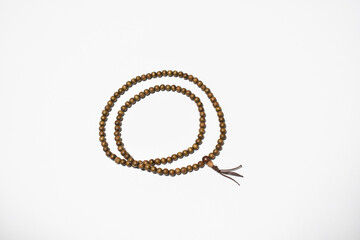 Brown wooden mala beads on a white background ringed two times