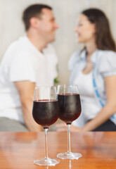 Young happy couple enjoying a glasses of red wine