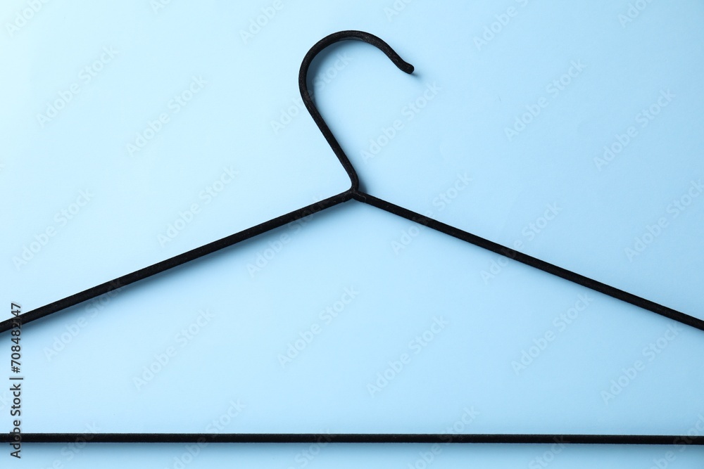 Wall mural One black hanger on light blue background, top view