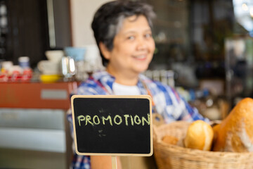 Asian elderly, senior, pensioner, female open cafe restaurant small business shop at home town after retirement, healthy strong 60s woman entrepreneur wearing apron working as barista waitress worker