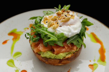 Salmon tartar with avocado, poached egg and arugula