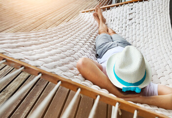 Man in hat in a hammock on a summer day