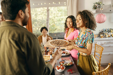 Happy friends enjoying in conversation during festive dinner at home party