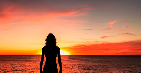 Fototapeta premium a pretty woman watching a sunset on the beach