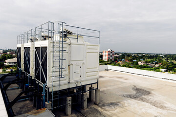 Cooling towers in data center building. Air conditioning cooling towers in front of building with fins to the front. Industrial cooling towers or air cooled water chillers with piping system.