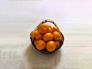 Resting on a rustic basket, the perfectly rounded orange gleams with vibrant color. Its smooth skin...