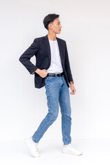 Confident Young Man Walking in Casual Business Attire. Stylish asian male posing in jeans and...