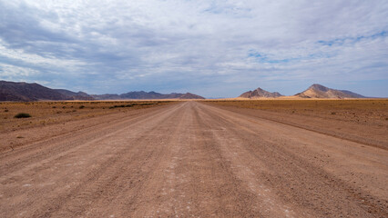 Driving along a long gravel road straight inside Namibia