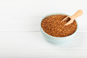 Raw buckwheat in a bowl on a textured background.Wheat grains, porridge, cereals, raw buckwheat in a plate. Healthy food. Porridge. Diet. Organic cerea. Space for text.Copy space.