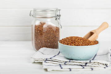 Raw buckwheat in a bowl on a textured background.Wheat grains, porridge, cereals, raw buckwheat in a plate. Healthy food. Porridge. Diet. Organic cerea. Space for text.Copy space.