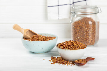 Raw buckwheat in a bowl on a textured background.Wheat grains, porridge, cereals, raw buckwheat in a plate. Healthy food. Porridge. Diet. Organic cerea. Space for text.Copy space.