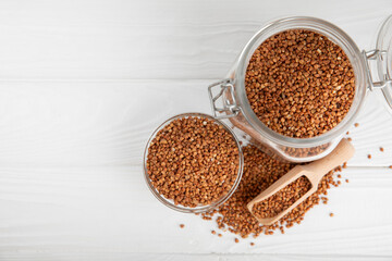 Raw buckwheat in a bowl on a textured background.Wheat grains, porridge, cereals, raw buckwheat in a plate. Healthy food. Porridge. Diet. Organic cerea. Space for text.Copy space.