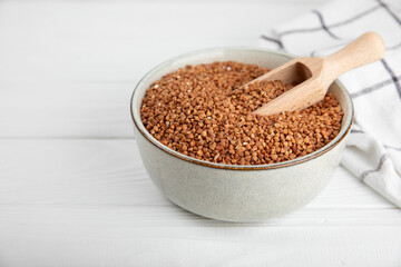 Raw buckwheat in a bowl on a textured background.Wheat grains, porridge, cereals, raw buckwheat in a plate. Healthy food. Porridge. Diet. Organic cerea. Space for text.Copy space.