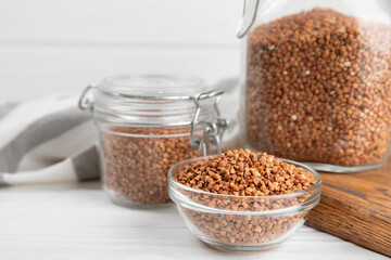 Raw buckwheat in a bowl on a textured background.Wheat grains, porridge, cereals, raw buckwheat in a plate. Healthy food. Porridge. Diet. Organic cerea. Space for text.Copy space.