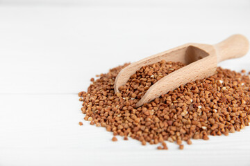 Raw buckwheat in a bowl on a textured background.Wheat grains, porridge, cereals, raw buckwheat in a plate. Healthy food. Porridge. Diet. Organic cerea. Space for text.Copy space.