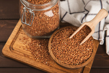 Raw buckwheat in a bowl on a textured background.Wheat grains, porridge, cereals, raw buckwheat in a plate. Healthy food. Porridge. Diet. Organic cerea. Space for text.Copy space.