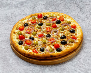 Homemade Italian style pizza with cheese, olives and black olives, onions, cherry tomatoes and minced meat close-up on a wooden board on the table. Horizontal