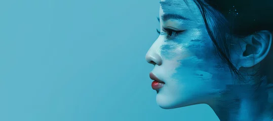 Keuken spatwand met foto Beautiful Asian woman side profile painted face view on bright blue wall studio background. Beauty, fashion, cosmetics concept © Alex Tihonov