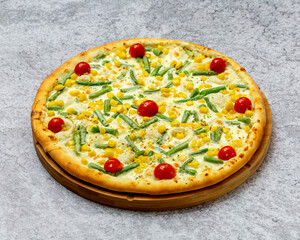 Homemade Italian style pizza with cheese, cherry tomatoes, beans, corn close-up on a wooden board on the table. Horizontal