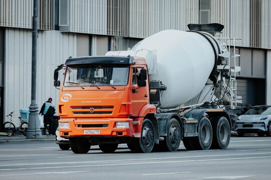 Concrete mixer truck driving on the street. Front side view of cement mixer in motion on urban highway