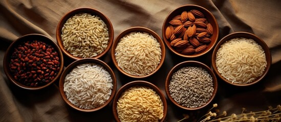 Assorted rice and grains in bowls on tablecloth. Top view.