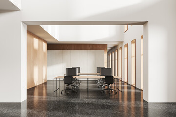 Cozy modern coworking interior with pc computers on desk in row