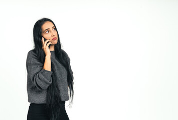 Disappointed, confused and angry young woman looking hopeless while talking on mobile on isolated white background with copy space. Unhappy young female brunette, dissatisfied by hearing bad news.