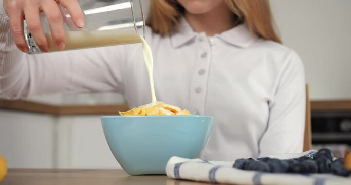 In modern kitchen girl's healthy eating ritual unfolds Slowly pouring milk she embraces healthy eating setting peaceful tone for school. Healthy eating in this kitchen is morning tradition.