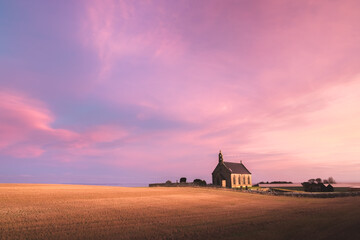 The lone chapel Boarhills Church during a colourful sunset or sunrise in the rural countryside...