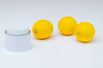 白いクリームの容器とレモン