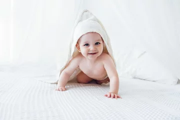 Tuinposter Little cute child wearing hooded towel after bath or shower. © Dasha Petrenko