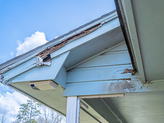 Distressed roofline of a house in need of repair because of dry rot and black mold from years of neglect.