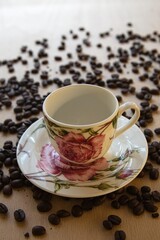 cup of hot coffee with coffee beans in the background